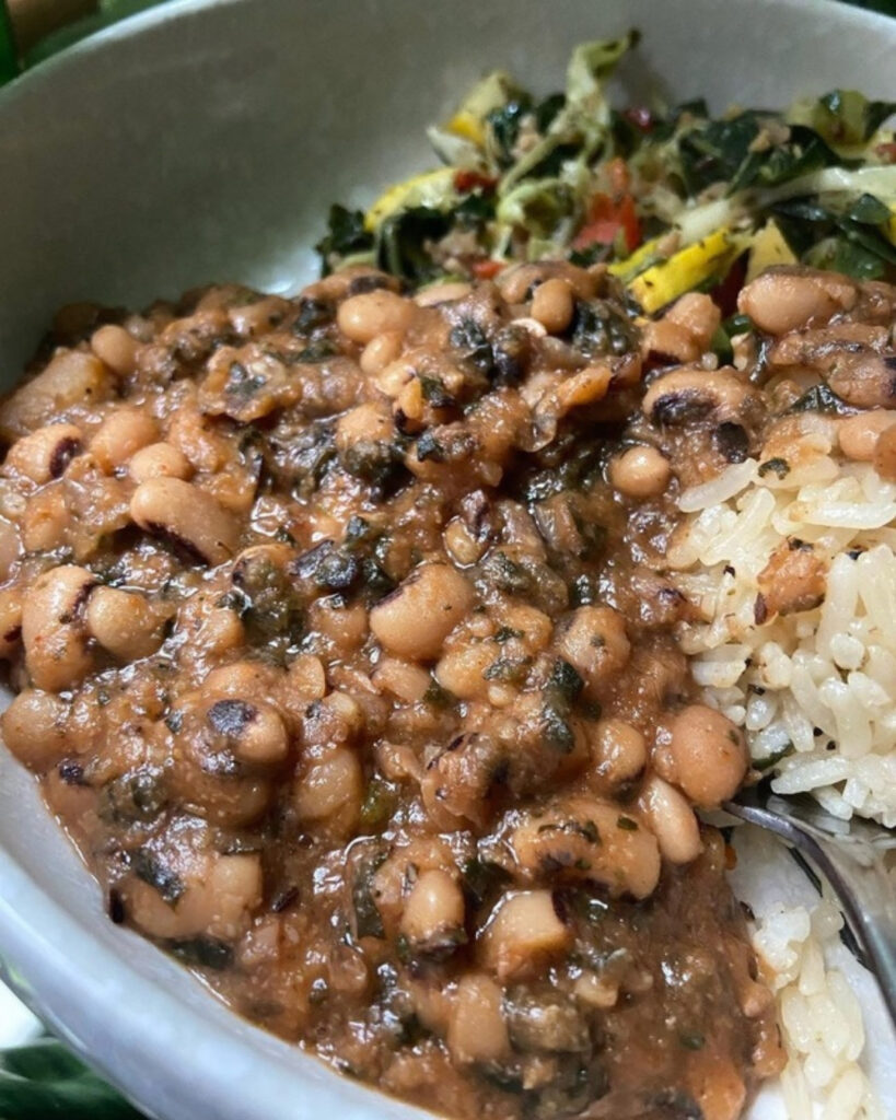 Bowl of Instant Pot black-eyed peas over herbed jasmine rice with sauteed collard greens