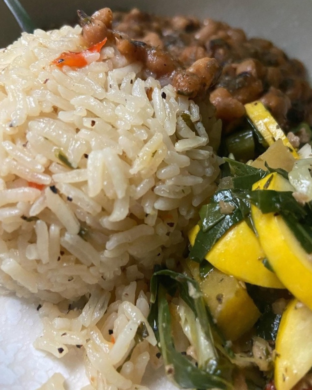 Fluffy herbed jasmine rice with parsley served next to sauteed greens